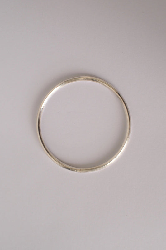 Silver bangle on a light gray background