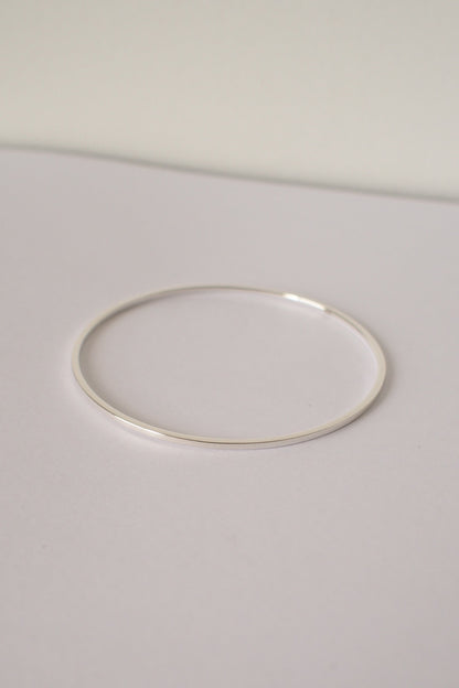 Silver square bangle on a light gray background